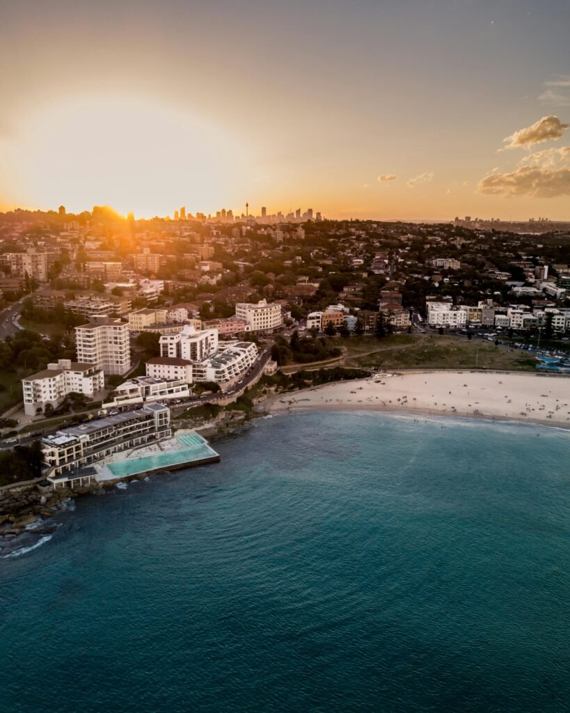 Stunning aerial view of Bondi Beach in Sydney at sunset, showcasing the coastline and cityscape.