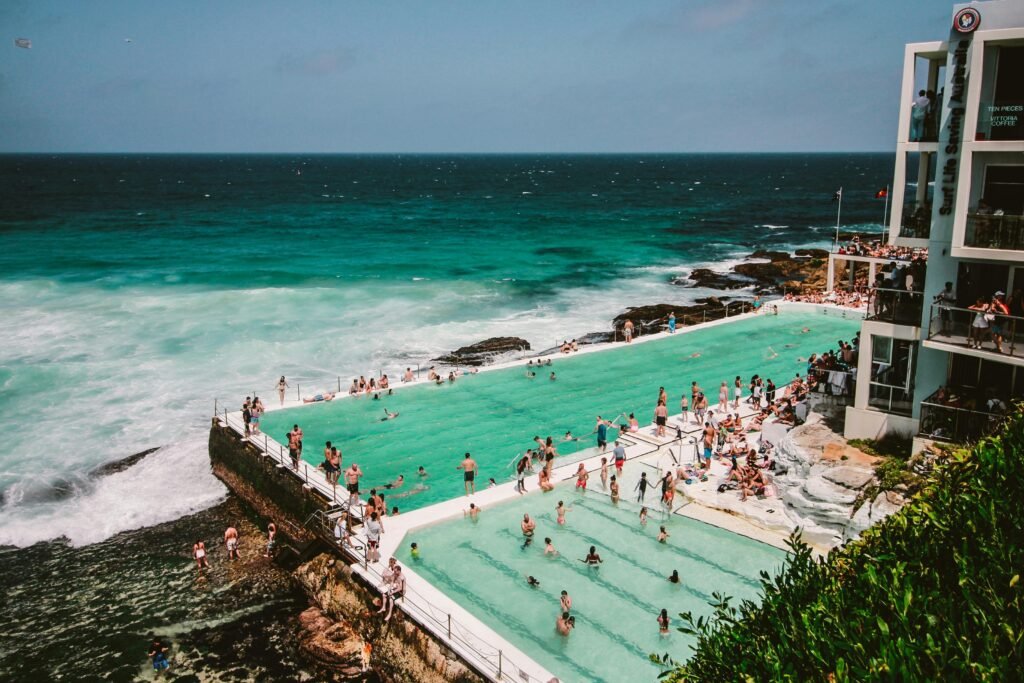 A vibrant scene of people enjoying the Bondi Icebergs swimming pool by the ocean in Sydney, Australia.
